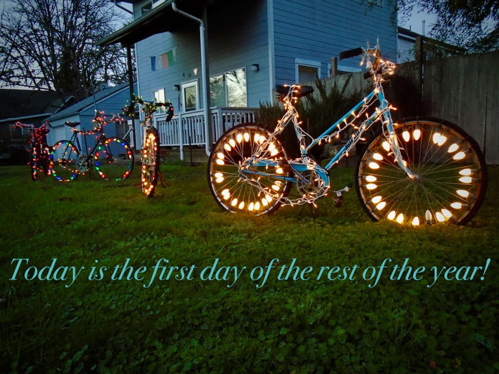 Solstice Cycles - a lawn with four bicycles decorated with holiday lights.